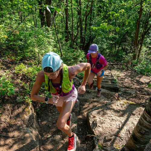 Deux coureuses gravissant un escalier rustique sur un sentier boisé pendant le Blue Bully Ultra