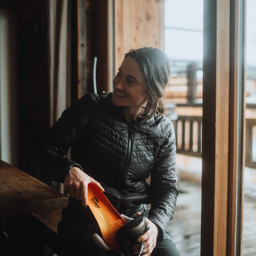 Une femme met une semelle dans sa botte.