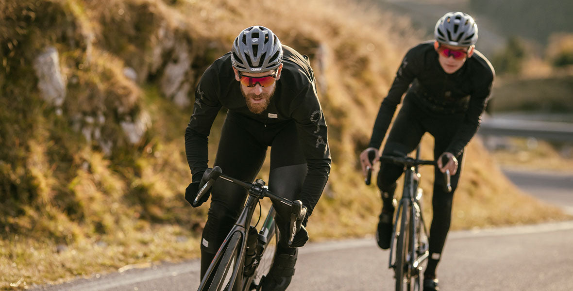 Deux cyclistes de route avec cuissards à bretelles et manteaux
